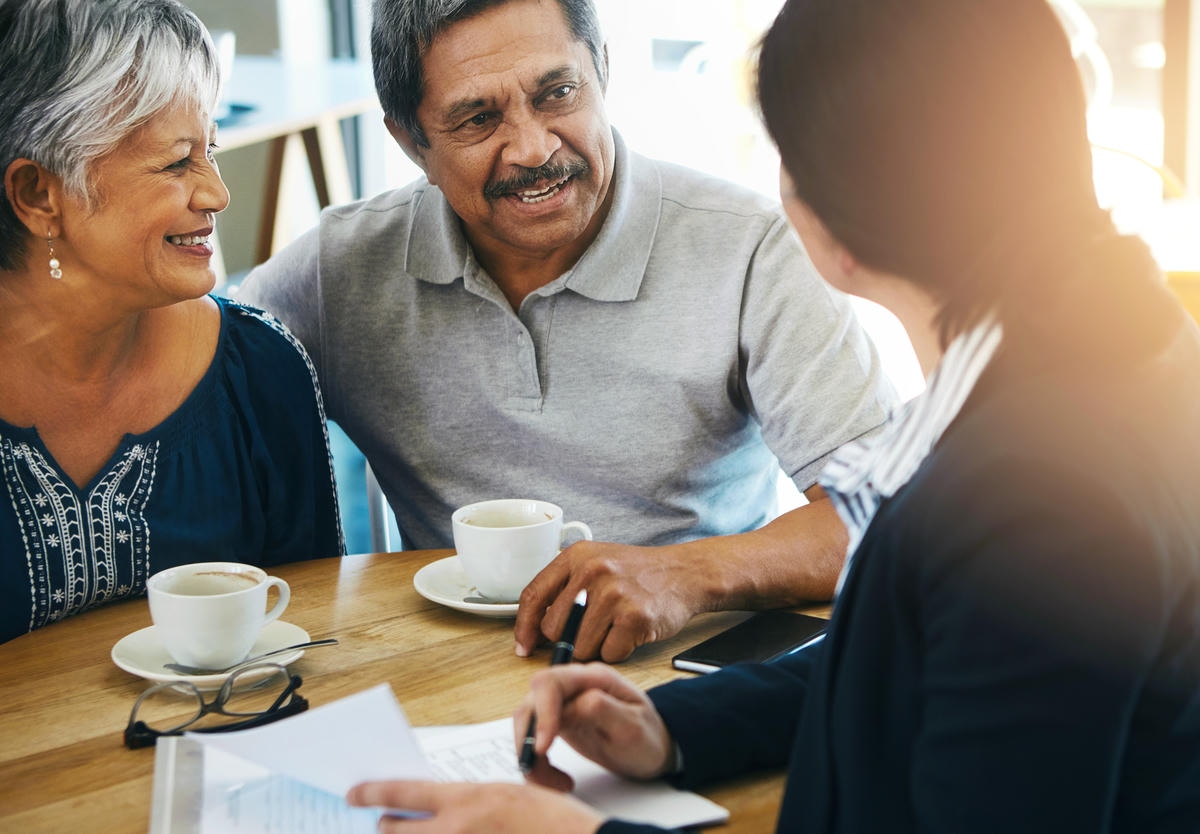 An advisor discussing healthcare and retirement planning with an older couple at home